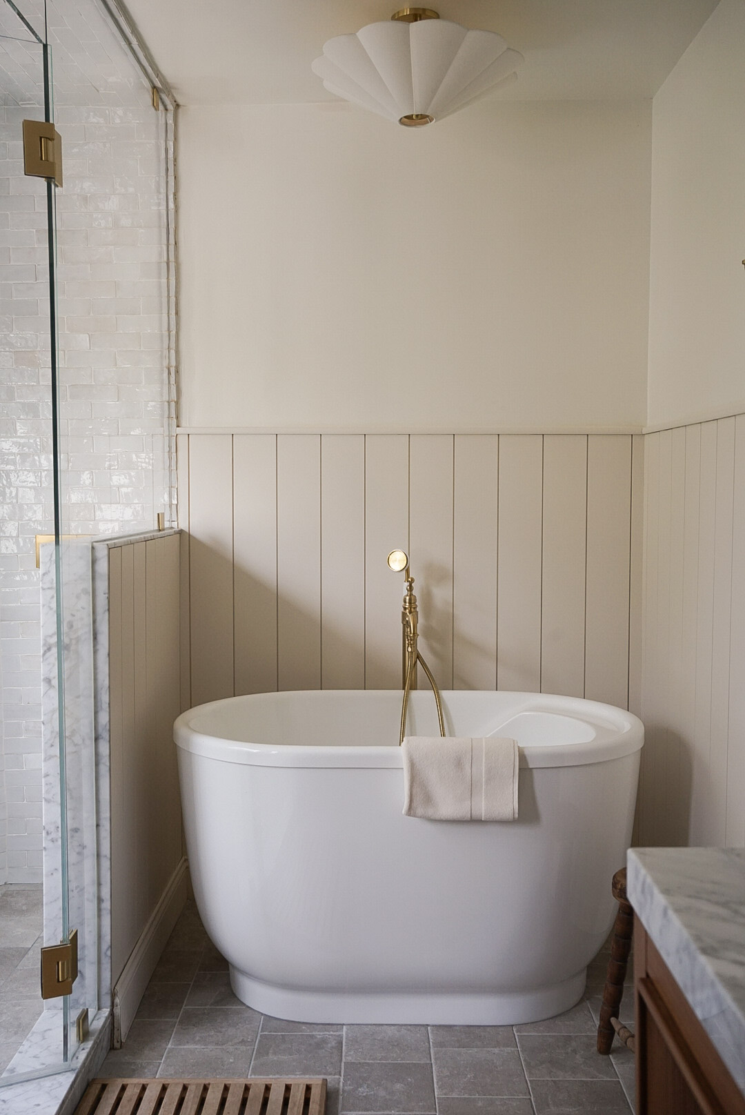 Vanity corner with silhouette portrait art and pleated sconce in Castle Pines primary bathroom